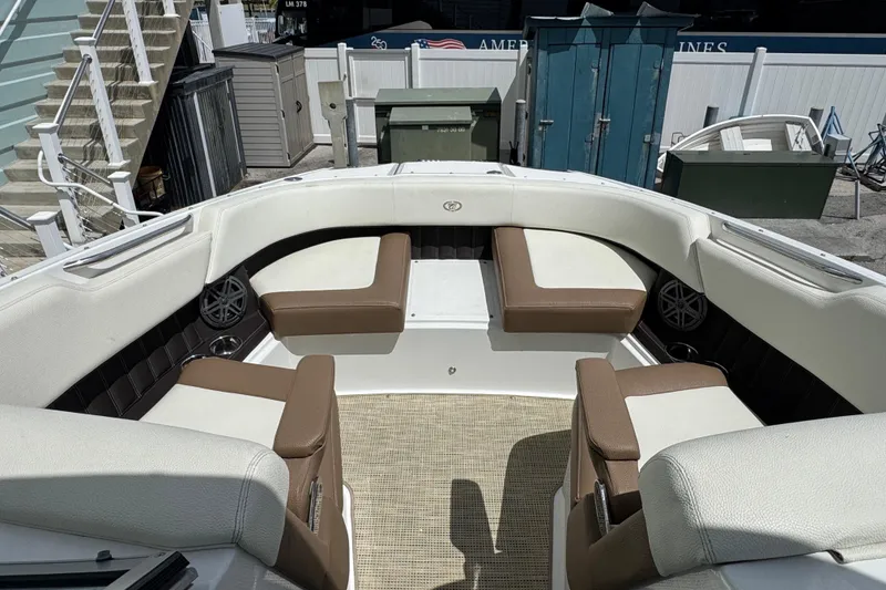 Slide: The Image of 2018 Cobalt 23SC boat interior with white and brown seating, outdoor setting. - 16