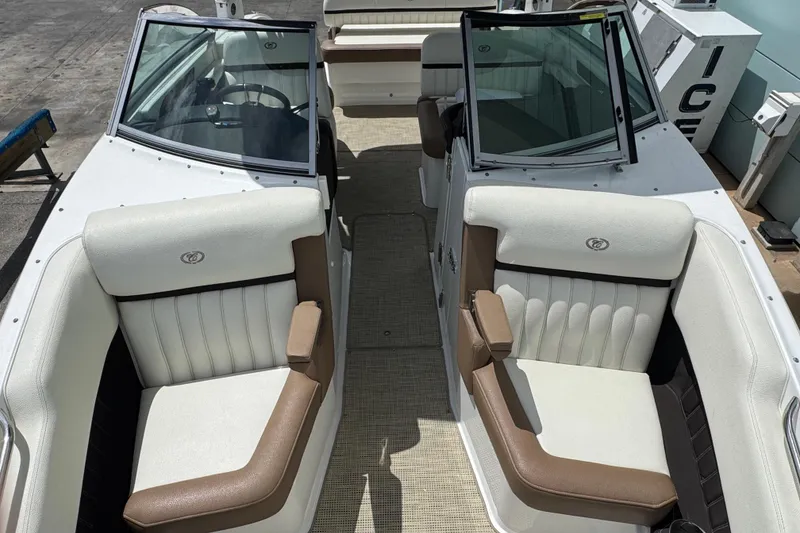 Slide: The Image of 2018 Cobalt 23SC boat interior with white and brown seating, open cockpit view. - 17