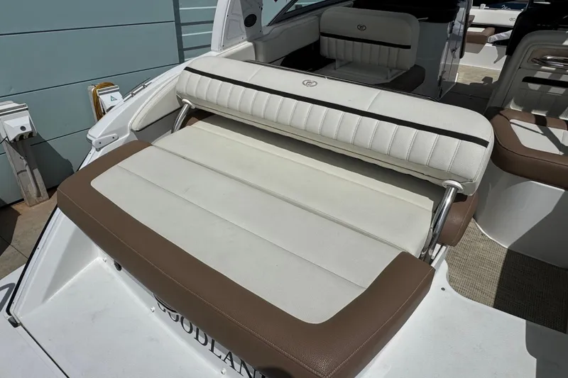 Slide: The Image of 2018 Cobalt 23SC boat with white and brown seating, docked outdoors. - 9