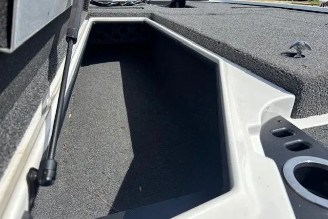 Slide: The Image of 2019 Nitro Z19 boat storage compartment with carpeted interior and rod holder. - 19