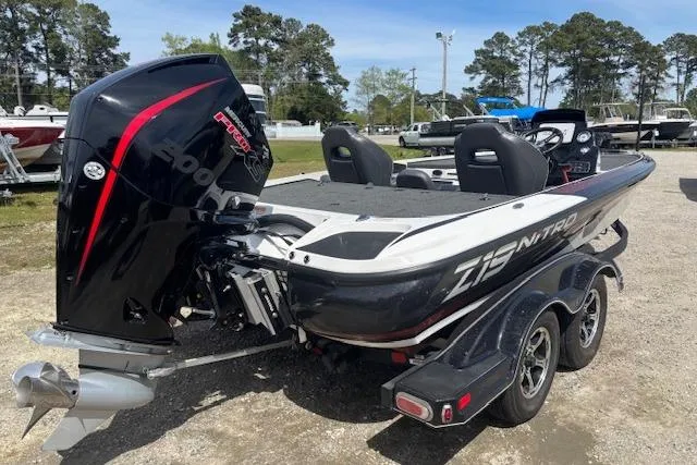 Slide: The Image of 2019 Nitro Z19 boat with powerful outboard motor, parked on a trailer in a marina. - 2
