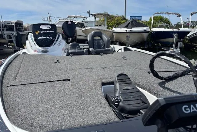 Slide: The Image of 2019 Nitro Z19 boat with fishing deck, seats, and motor, docked among other boats. - 21