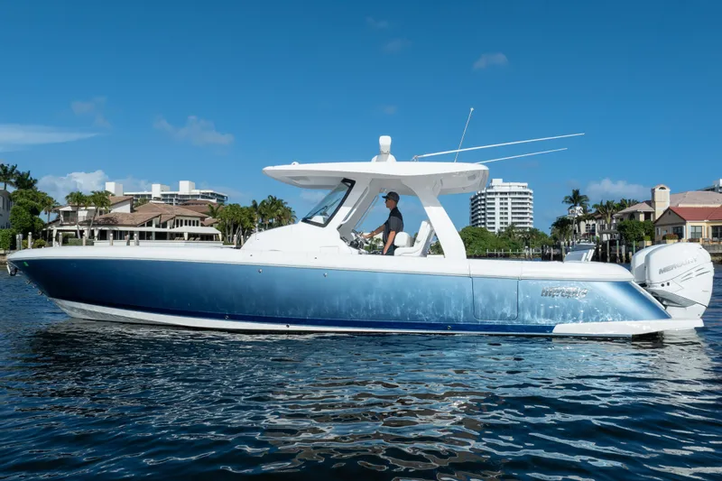 Slide: The Image of 2022 Intrepid 345 Nomad SE boat cruising on a sunny day near waterfront homes. - 13