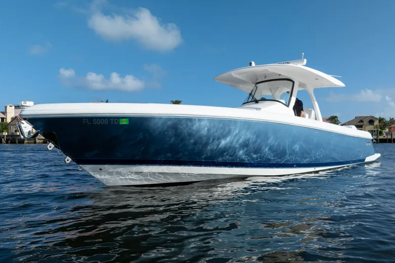 Slide: The Image of 2022 Intrepid 345 Nomad SE boat on water, blue hull, sunny day. - 15