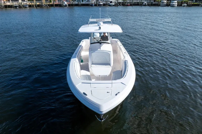 Slide: The Image of 2022 Intrepid 345 Nomad SE boat cruising on calm waters, showcasing sleek design and spacious deck. - 16
