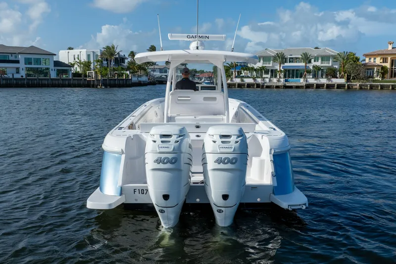 Slide: The Image of 2022 Intrepid 345 Nomad SE boat with twin 400 Verado engines on a sunny waterfront. - 17