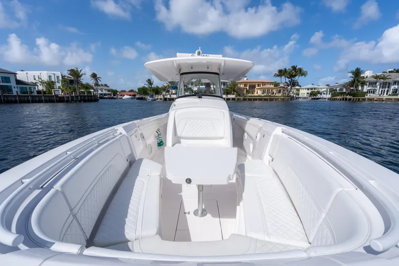 Slide: The Image of 2022 Intrepid 345 Nomad SE boat on a sunny waterfront, featuring spacious seating and sleek design. - 21