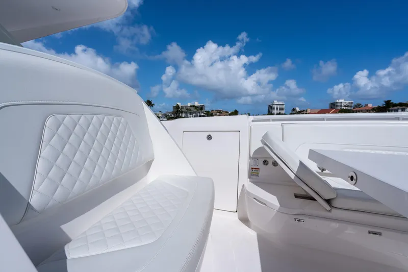 Slide: The Image of Luxurious seating on 2022 Intrepid 345 Nomad SE boat under clear blue sky. - 23