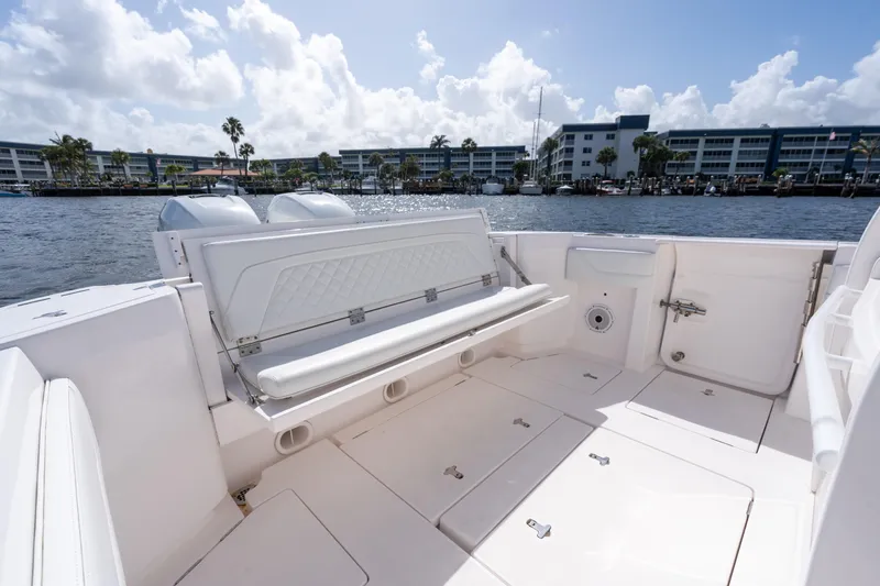 Slide: The Image of 2022 Intrepid 345 Nomad SE boat interior with seating, dockside view, and clear skies. - 27