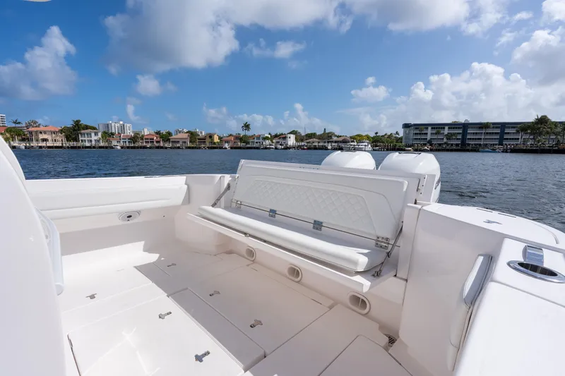 Slide: The Image of 2022 Intrepid 345 Nomad SE boat interior with waterfront view, clear skies, and luxurious seating. - 28