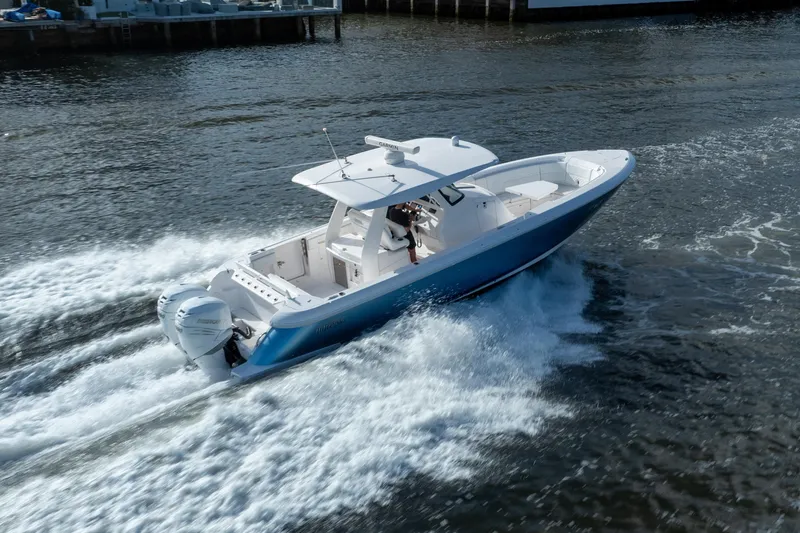 Slide: The Image of 2022 Intrepid 345 Nomad SE boat cruising on water, showcasing sleek design and powerful engines. - 3
