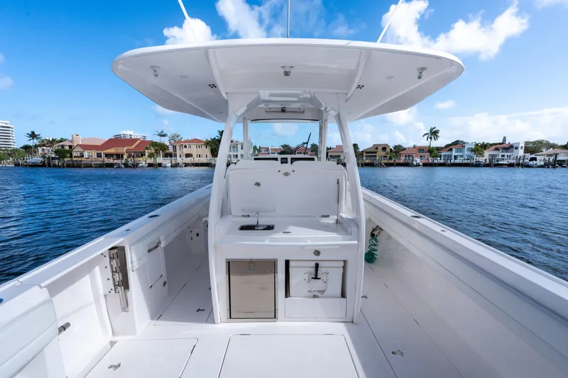 Slide: The Image of 2022 Intrepid 345 Nomad SE boat on calm water, showcasing sleek design and spacious deck. - 32