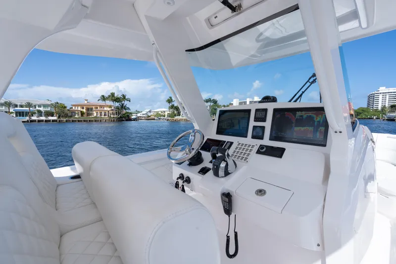 Slide: The Image of 2022 Intrepid 345 Nomad SE boat cockpit with modern navigation equipment and luxurious seating. - 34