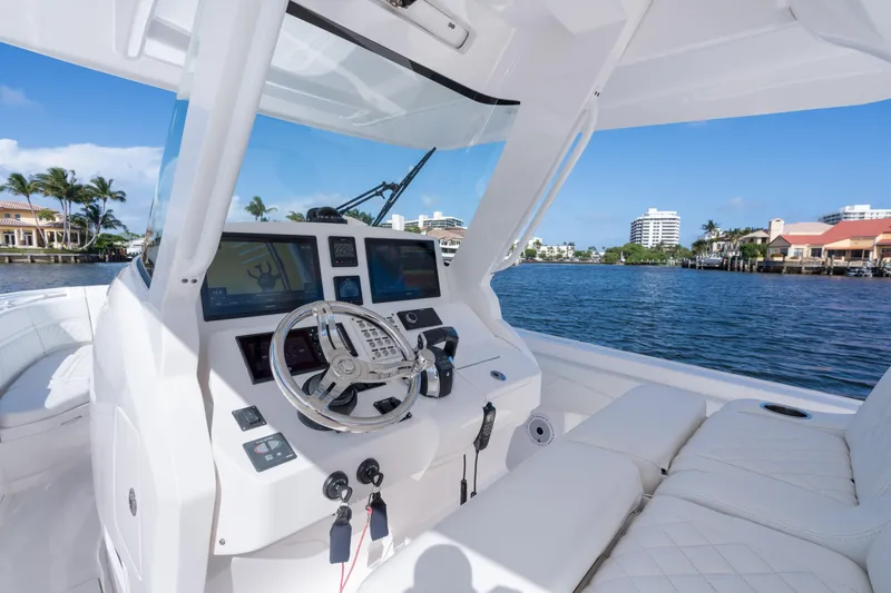 Slide: The Image of 2022 Intrepid 345 Nomad SE boat cockpit with modern controls and waterfront view. - 36