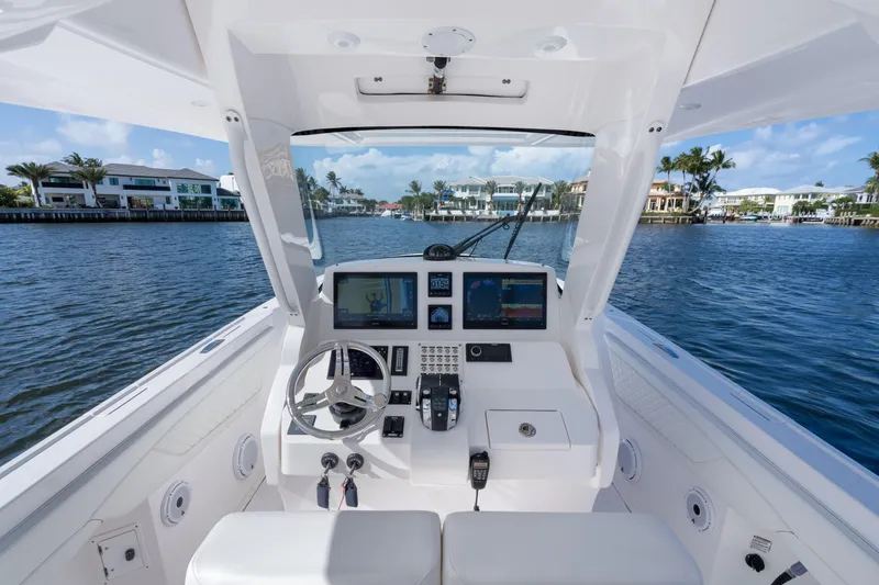 Slide: The Image of Cockpit view of 2022 Intrepid 345 Nomad SE boat on a scenic waterway. - 37