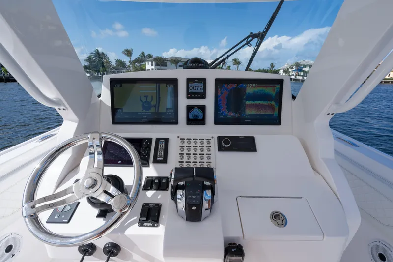 Slide: The Image of Intrepid 345 Nomad SE 2022 boat dashboard with steering wheel and navigation screens. - 38