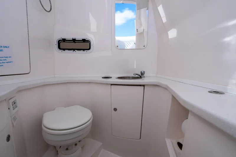 Slide: The Image of 2022 Intrepid 345 Nomad SE boat bathroom with toilet, sink, and window. - 40