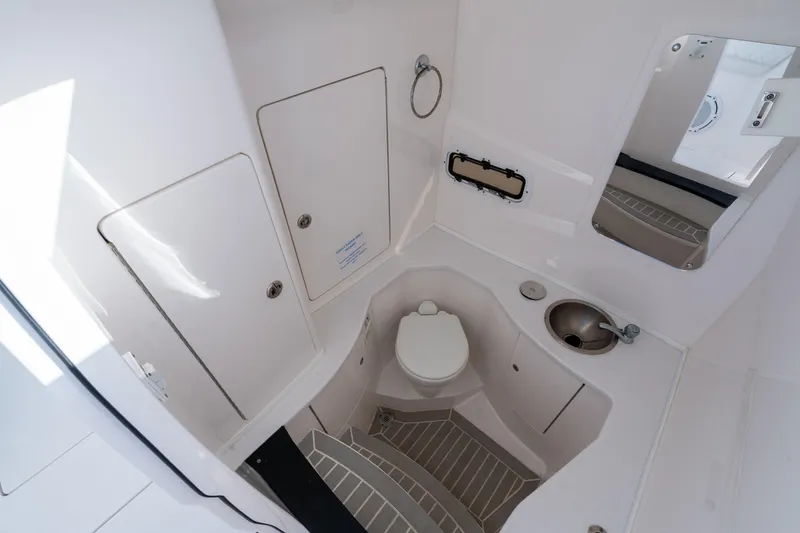 Slide: The Image of 2022 Intrepid 345 Nomad SE boat bathroom with toilet, sink, and mirror. - 41