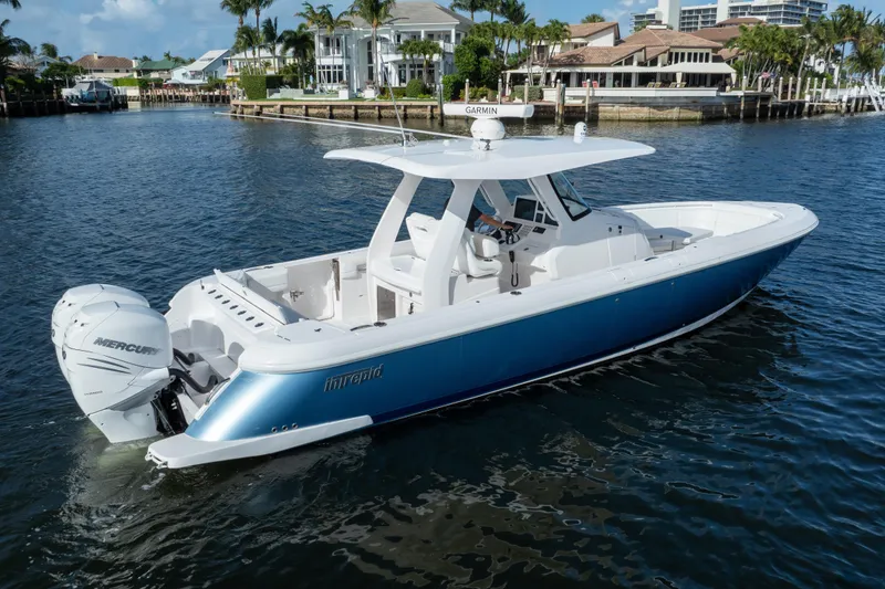 Slide: The Image of 2022 Intrepid 345 Nomad SE boat on water, featuring sleek design and powerful Mercury engines. - 7