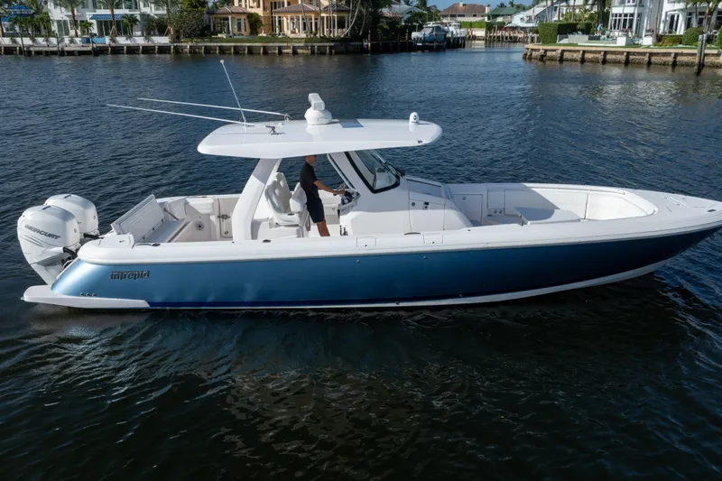 Slide: The Image of 2022 Intrepid 345 Nomad SE boat cruising on a calm waterway. - 8