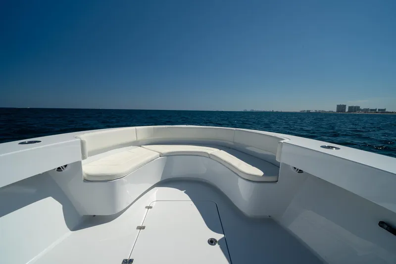 Slide: The Image of Bow seating area on 2026 Conch 33 boat, overlooking ocean and distant city skyline. - 11