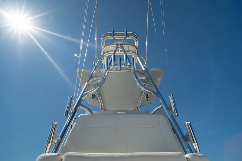 Slide: The Image of Conch 33 boat tower against clear blue sky, 2026 model, with bright sun overhead. - 24