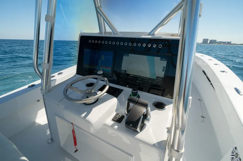 Slide: The Image of 2026 Conch 33 boat dashboard with steering wheel and navigation screens on open water. - 28