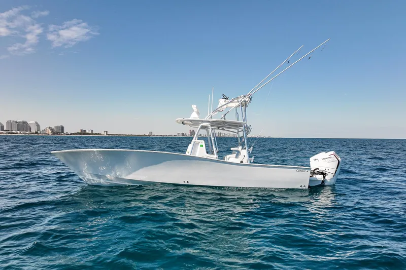 Slide: The Image of 2026 Conch 33 boat on open sea with city skyline in background. - 3