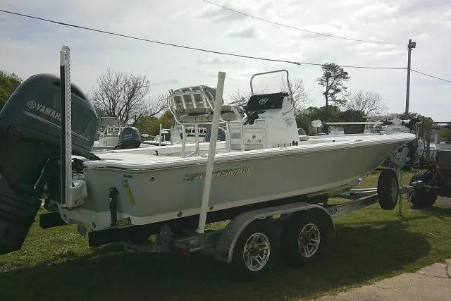 Slide: The Image of 2022 Sportsman Tournament 214 Bay Boat on trailer with Yamaha engine, parked outdoors. - 13