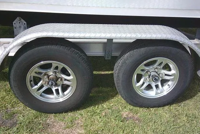 Slide: The Image of Trailer wheels of a 2022 Sportsman Tournament 214 Bay Boat on grass. - 9