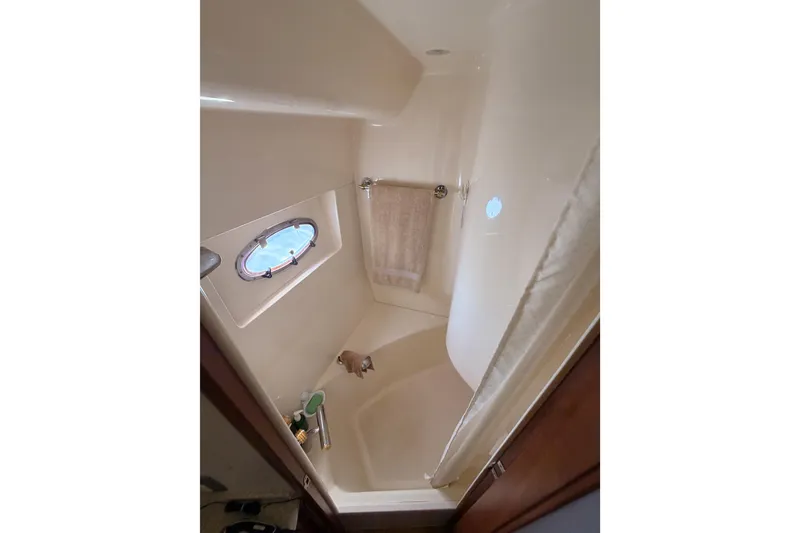 Slide: The Image of 1999 Carver 530 Voyager Pilothouse bathroom with shower and porthole window. - 97