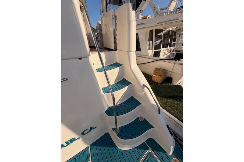 Slide: The Image of 1998 Sea Ray 420 Aft Cabin boat steps with teal accents and railing. - 12