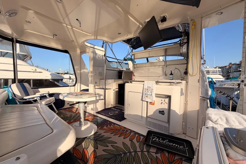Slide: The Image of 1998 Sea Ray 420 Aft Cabin interior with seating, table, and kitchenette. - 13
