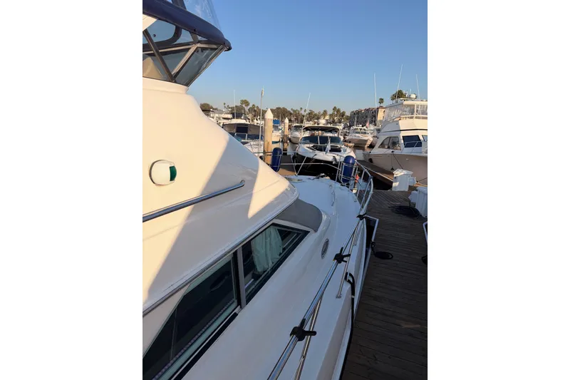 Slide: The Image of 1998 Sea Ray 420 Aft Cabin yacht docked at marina, side view. - 15