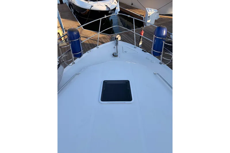 Slide: The Image of 1998 Sea Ray 420 Aft Cabin yacht deck with docked boats in background. - 16