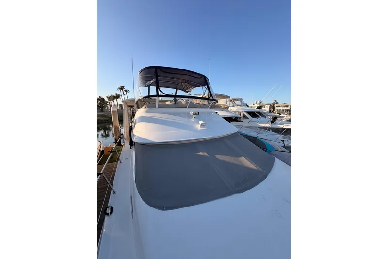 Slide: The Image of 1998 Sea Ray 420 Aft Cabin yacht docked under clear blue sky. - 19