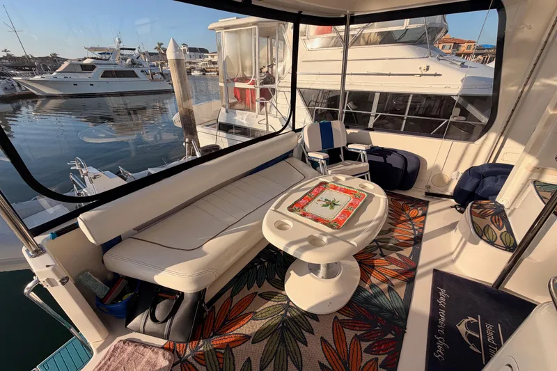 Slide: The Image of 1998 Sea Ray 420 Aft Cabin yacht interior with seating, table, and marina view. - 21