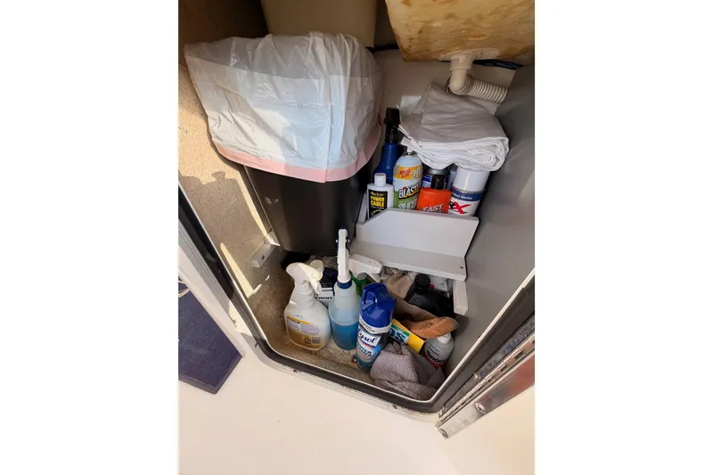 Slide: The Image of Storage compartment on 1998 Sea Ray 420 Aft Cabin with cleaning supplies and trash bin. - 24