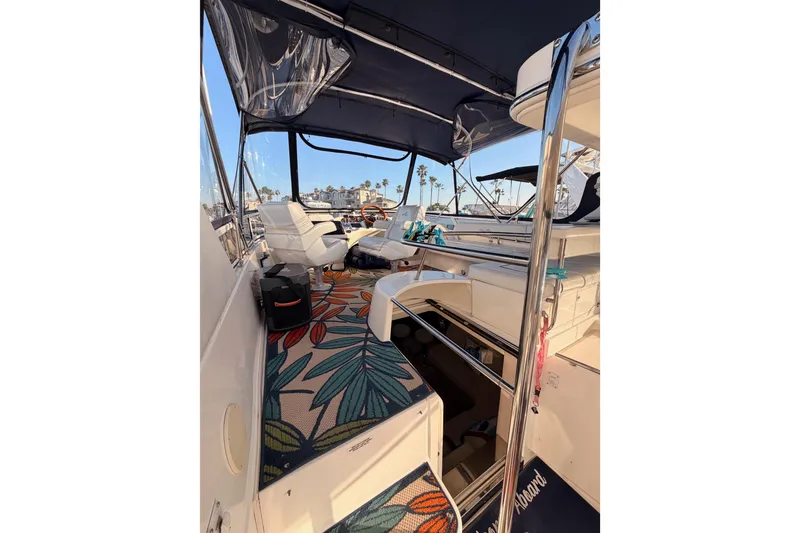 Slide: The Image of 1998 Sea Ray 420 Aft Cabin interior with floral carpet and white seating. - 27