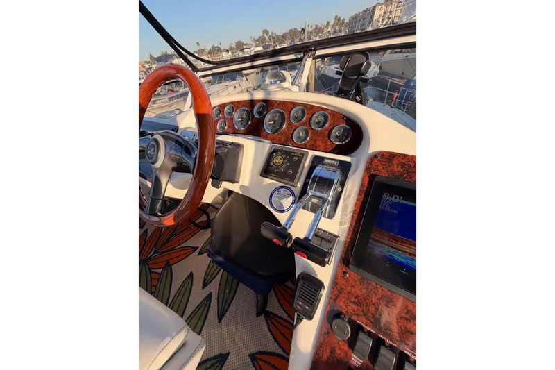 Slide: The Image of 1998 Sea Ray 420 Aft Cabin helm with wood accents and modern controls. - 33