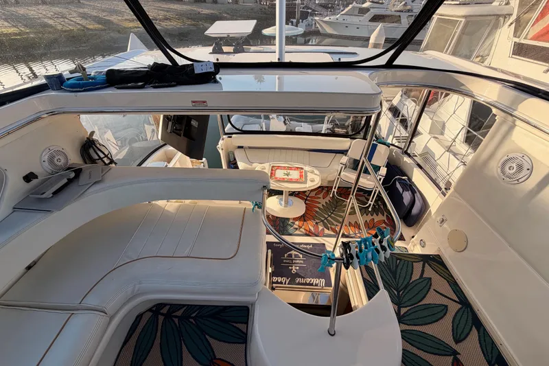 Slide: The Image of 1998 Sea Ray 420 Aft Cabin interior with seating and table, docked at marina. - 38