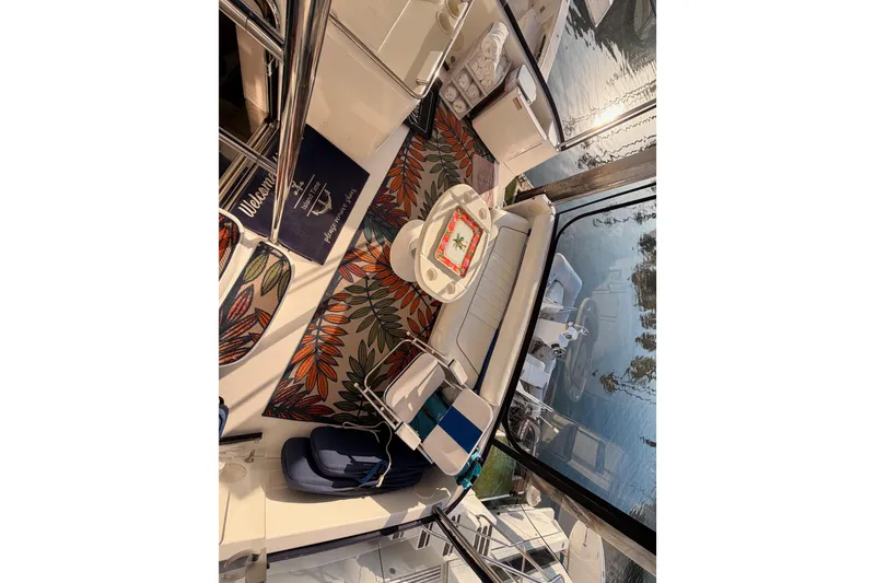 Slide: The Image of 1998 Sea Ray 420 Aft Cabin interior with colorful rug and seating area. - 41