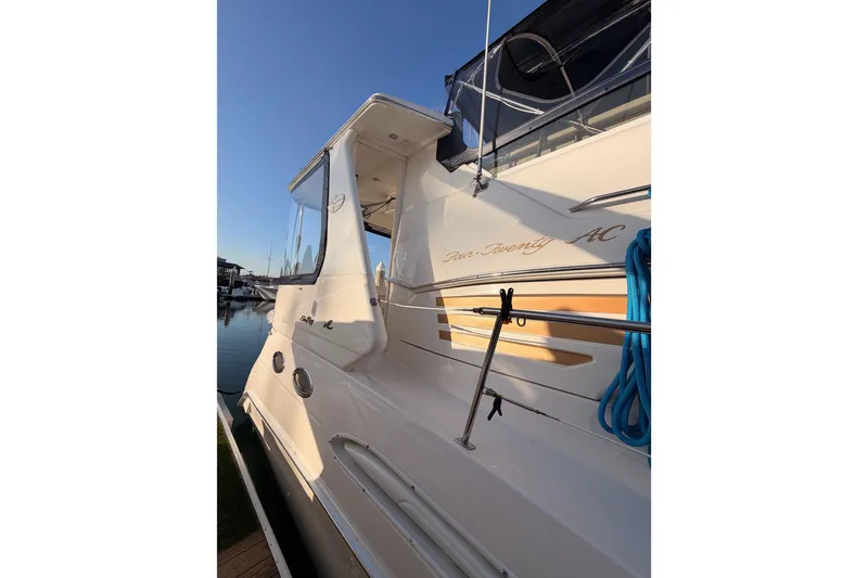 Slide: The Image of 1998 Sea Ray 420 Aft Cabin yacht docked, showcasing sleek design and blue rope detail. - 5