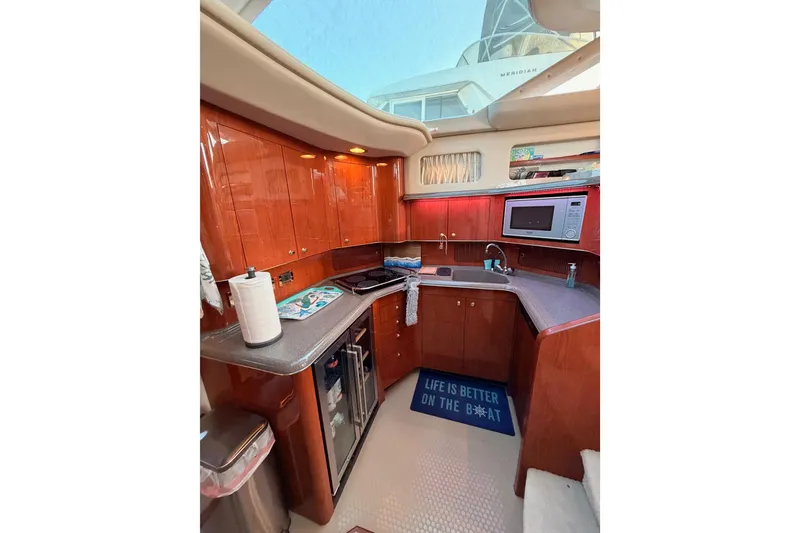 Slide: The Image of 1998 Sea Ray 420 Aft Cabin kitchen with wood cabinets, microwave, and sink. - 52