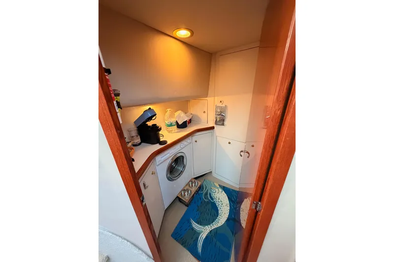 Slide: The Image of Laundry area in 1998 Sea Ray 420 Aft Cabin with washer, counter, and fish-themed rug. - 57