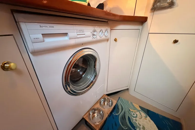 Slide: The Image of Laundry area in 1998 Sea Ray 420 Aft Cabin with washer and pet bowls. - 58