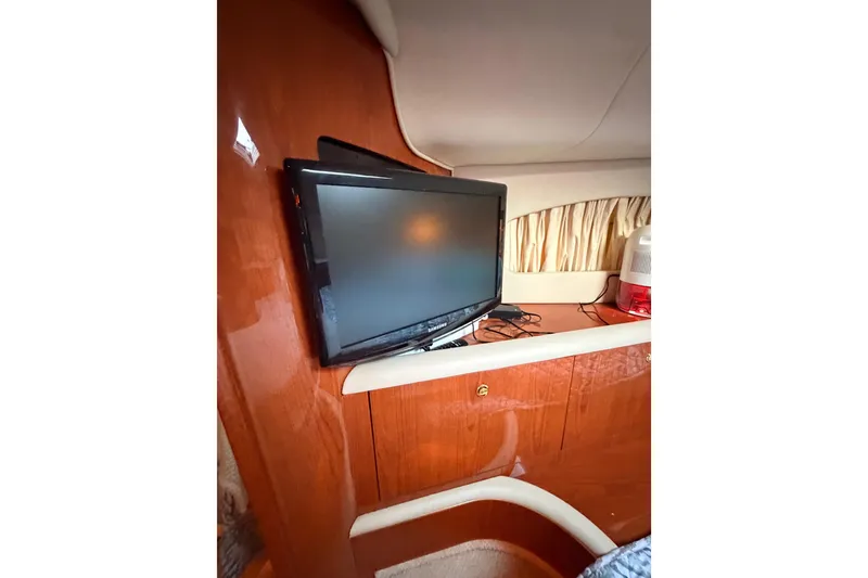 Slide: The Image of 1998 Sea Ray 420 Aft Cabin interior with mounted TV and wooden cabinetry. - 66