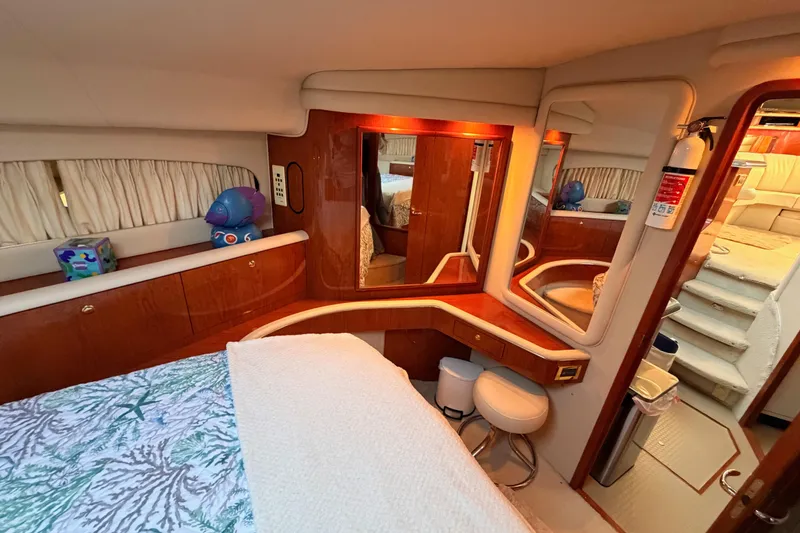 Slide: The Image of Luxurious 1998 Sea Ray 420 Aft Cabin interior with elegant wood finishes and cozy seating. - 67