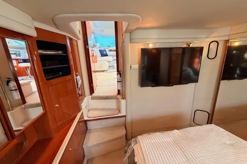 Slide: The Image of Interior of 1998 Sea Ray 420 Aft Cabin with TV, stairs, and wood cabinetry. - 77