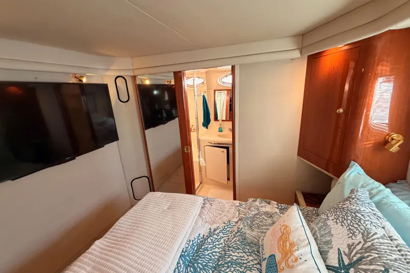 Slide: The Image of 1998 Sea Ray 420 Aft Cabin interior with cozy bedroom and ensuite bathroom. - 78